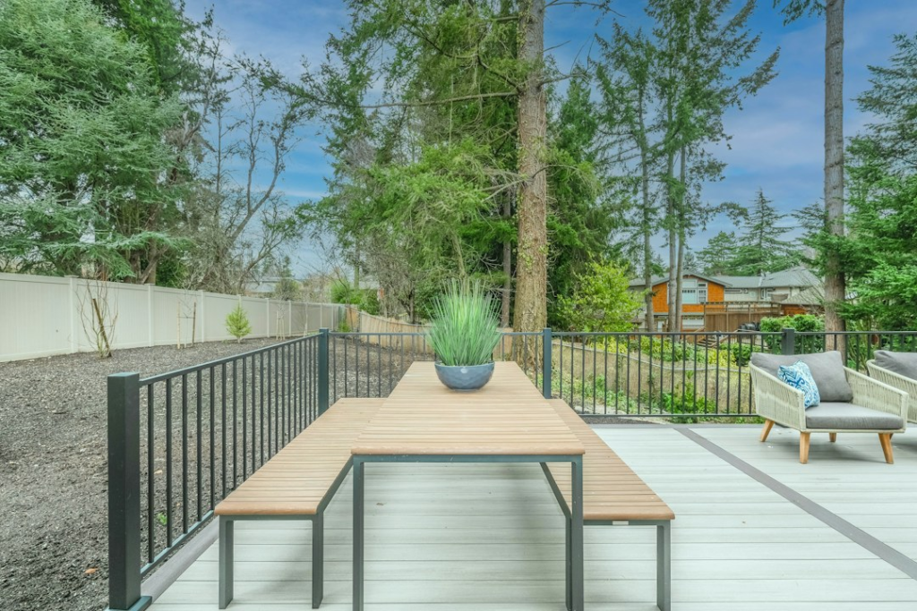 Finished backyard deck with railing beside a house
