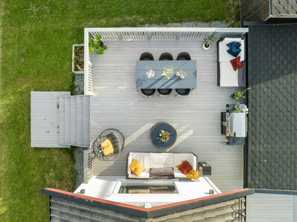 Aerial view of a light gray backyard deck arranged for dining and outdoor living