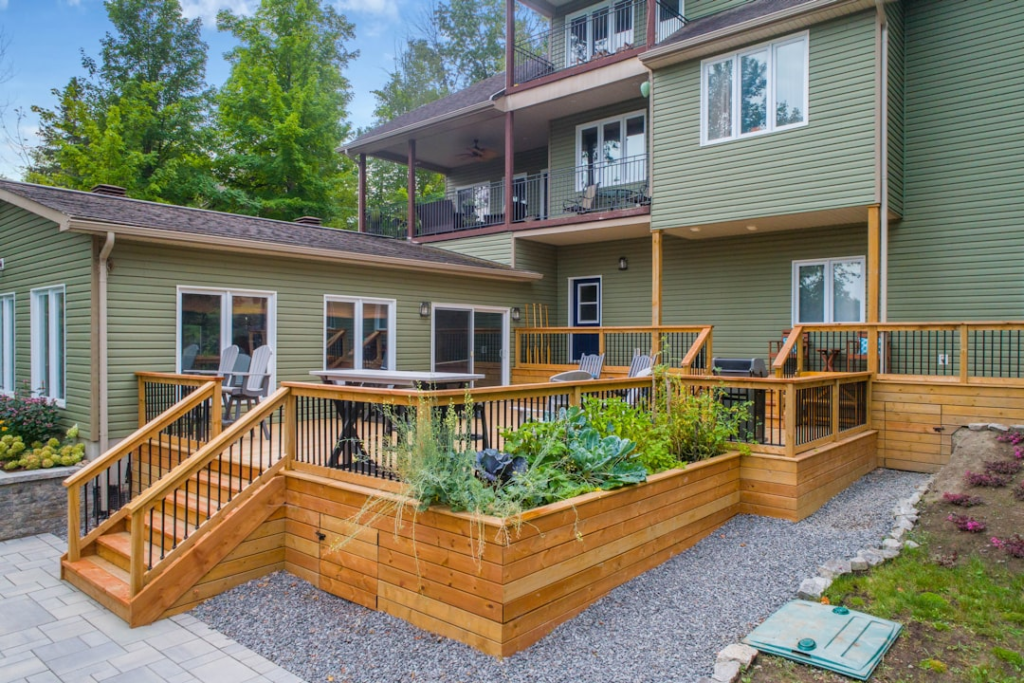 Natural wood backyard deck with stairs, black balusters and an integrated planter