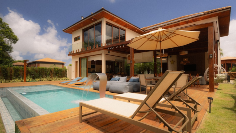 Warm-toned wood deck surrounding a modern backyard pool and outdoor living area
