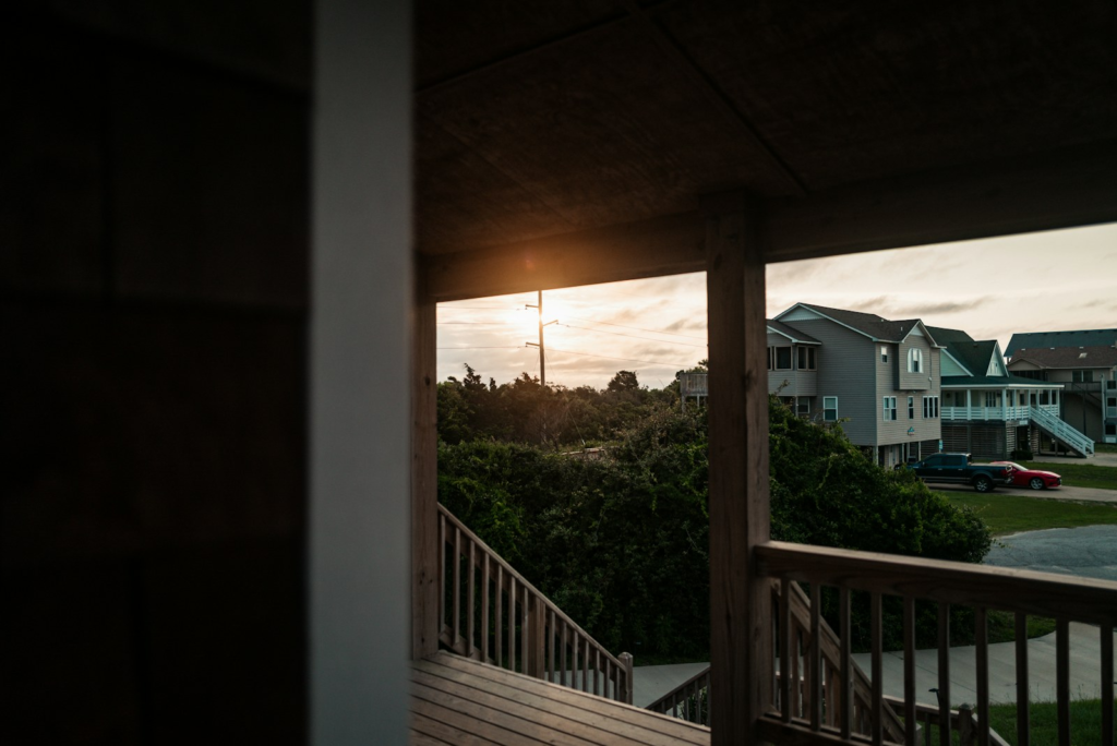 Residential wood deck railing overlooking nearby homes. Photo by Mario Scheibl on Unsplash.